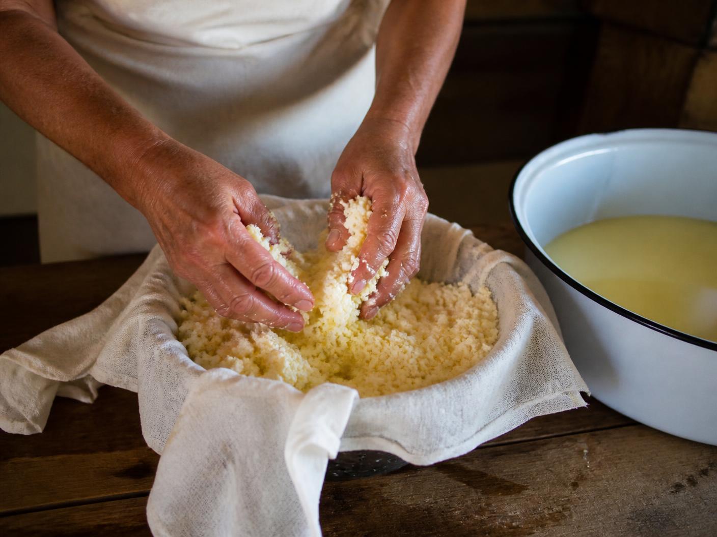 Mãos preparando queijo artesanal